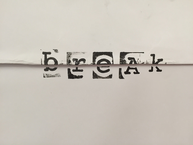 Sample maker manifesto page, featuring the word "break" stamped with rubber stamps across a fold in a piece of 12x12" scrapbook paper